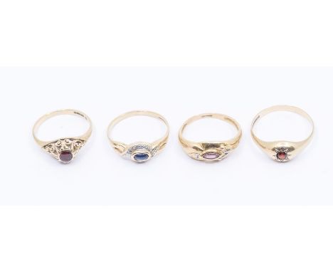 A collection of four stone set 9ct gold rings to include a sapphire ring set with a cabochon oval sapphire, size P, a ruby ri