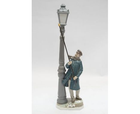 A large Lladro figure of a man lighting a street lamp - 46cm high.