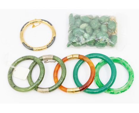 A collection of round section bangles to include two nephrite type jade, agate and hematite both with gilt overlays, a carved