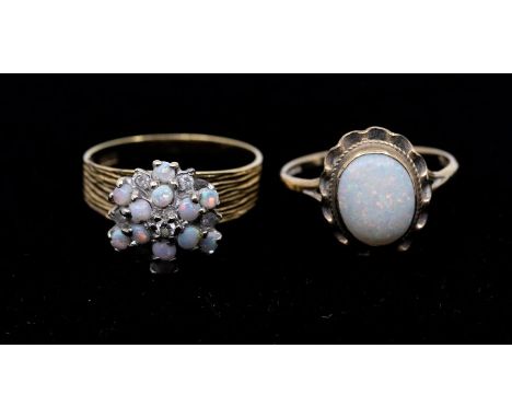 An opal and diamond 18ct gold cluster comprising a cluster of small round cabochon opals with four small diamond accents, set