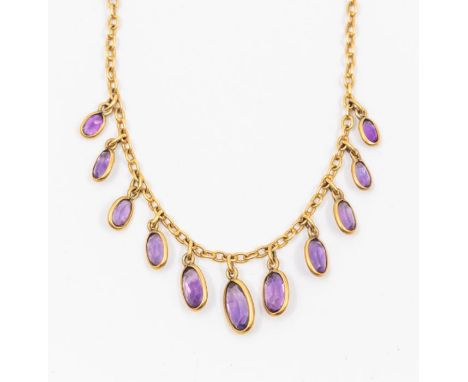 An early 20th century amethyst and gold fringe style necklace, comprising fine chain suspending a row of optical set graduate