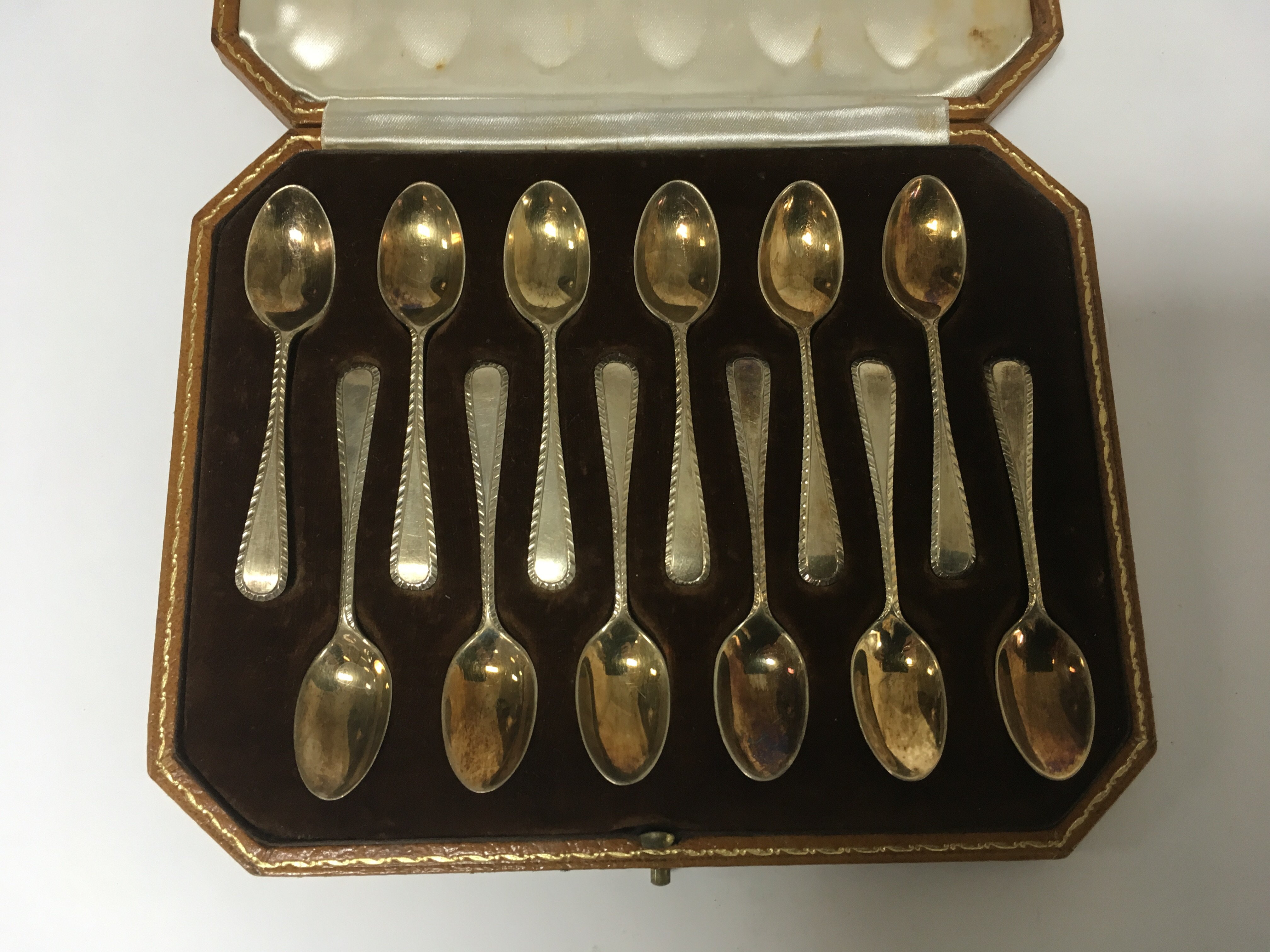 A set of twelve silver gilt tea spoons fitted in a Harrods case London ...