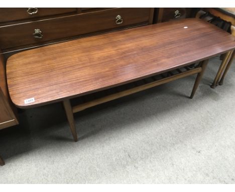 An Ercol style coffee table with a rectangular top above turned tapering legs with magazine rack under