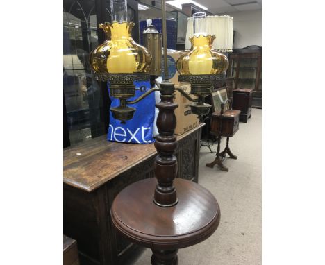  A twin oil lamp on mahogany stand with amber shades and glass funnels