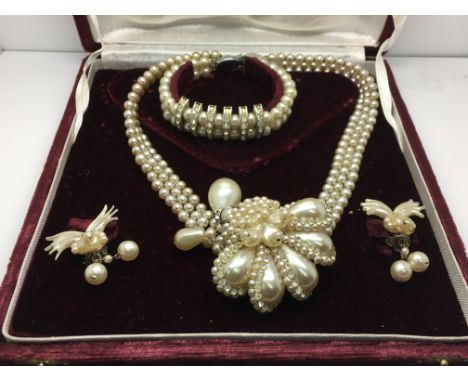 A boxed jewellery set comprising of a necklace, pair of earrings and a bracelet all set with mother of pearl and decorated wi