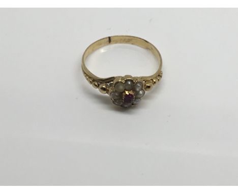 A Victorian 18ct Gold ring set with a central ruby and seed pearl. Ring size J,