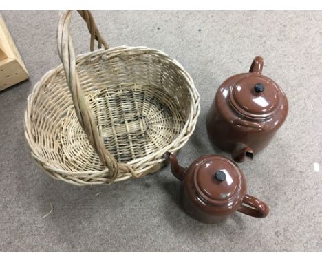 An old wicker mushrooming basket and brown enamelled judgeware teapot and kettle