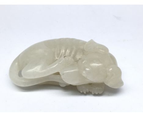 A small carved white jade model of a sleeping dog.Approx 5cm long.