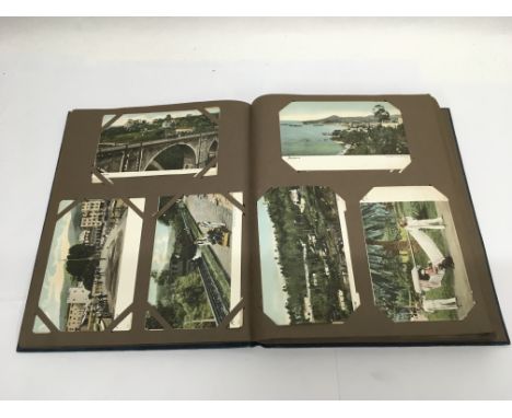 A vintage postcard album and contents.