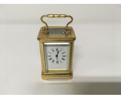 A small brass case carriage clock the enamel dial with Roman numerals 