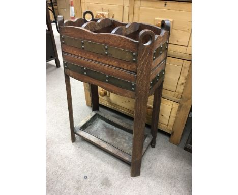 An oak stick stand decorated with metal straps.