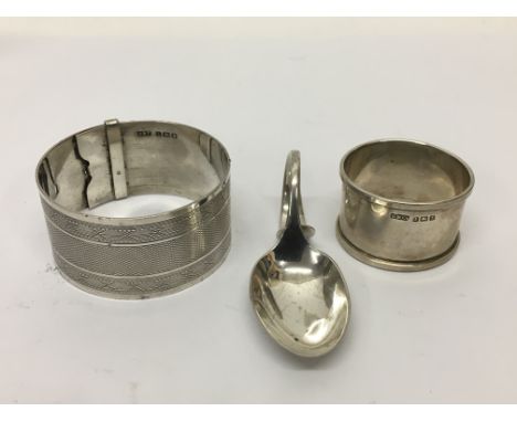 A silver bangle, napkin ring and spoon (3).