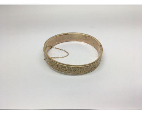 A 9ct Gold bangle with folate decoration, 23g approximately.