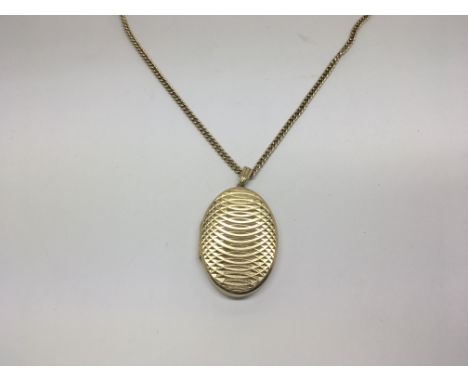A 9ct gold oval locket with attached gold chain, weighs 19g approx.