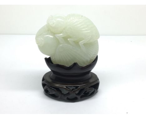 Another small carved, light green jade model of a grasshopper on a flower bud, with carved wooden stand