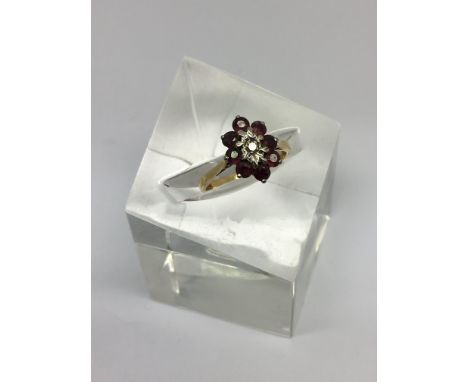 An 18ct gold and ruby cluster ring set with diamond chip