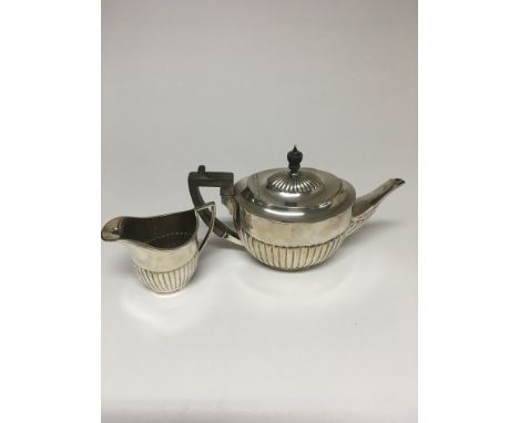 A silver teapot Sheffield hallmarks 1930 And  a milk jug Sheffield hallmarks 1922 , 623 grams 