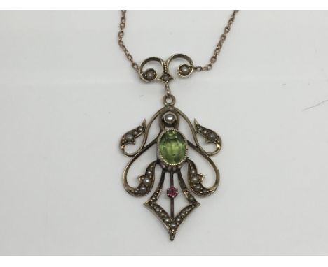 An Edwardian Gold pendent with a good size green Peridot with further Ruby’s and seed pearl, with attached 9ct Gold chain.