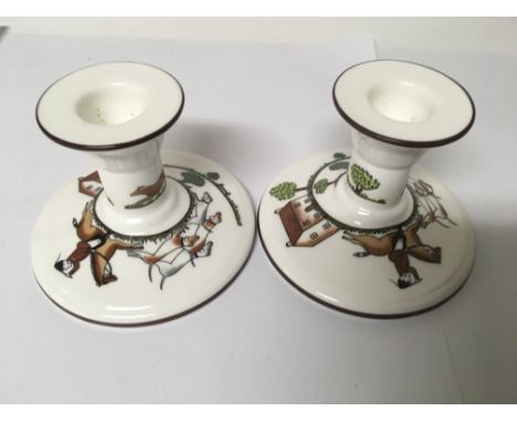 A pair of crown Staffordshire candlesticks depicting fox hunting scenes.