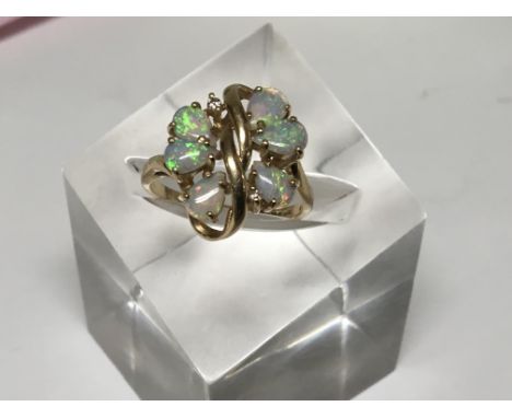 A 15ct yellow gold opal ring of unusual naturalist form with six Opals and small diamond ring size R. 