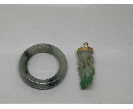 A gold mounted and carved jade pendant drop and a jade ring