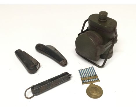 A 1950s United Nations Korea medal, two military jackknives, wartime bike lamp and Victorian penknife stamped 'Greenwich inla