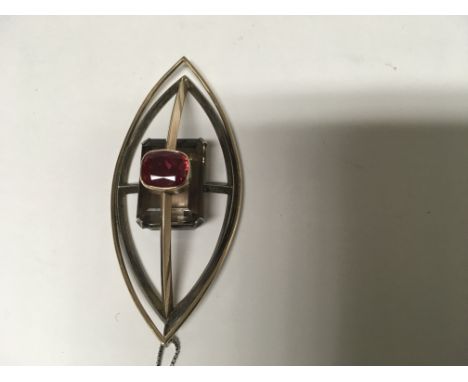 A Morden design pendant of oval form in 9ct yellow gold and silver inset with smokey quartz and a red tourmaline with attache