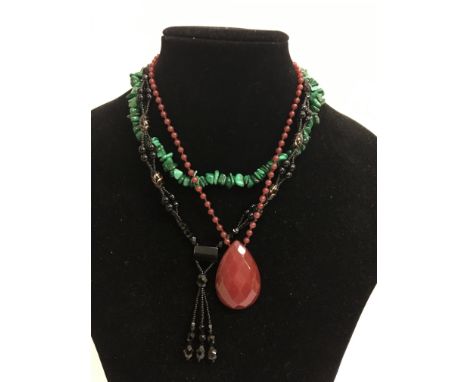 Three necklaces comprising malachite, jet and ruby coloured