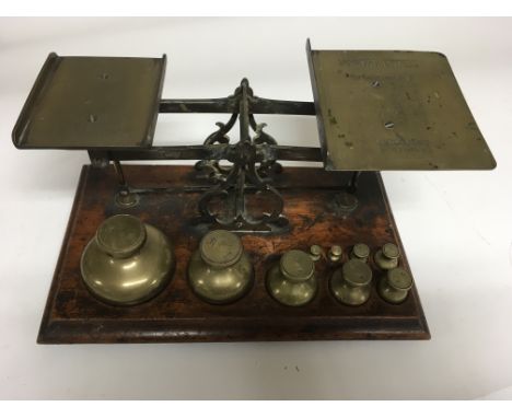 A set of beam balance scales with graduating set of brass weights