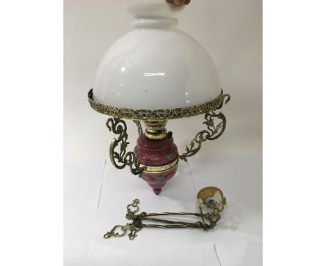 A painted ceramic and brass hanging oil lamp with white glass shade, approx