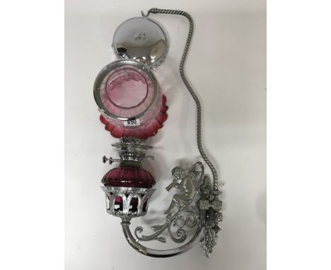 A Romany  hanging oil lamp with cranberry font and shade the plated frame in the form of a cherub 