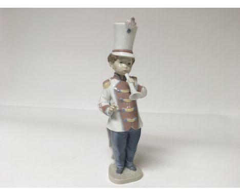 A Lladro figure of a boy playing an instrument 
