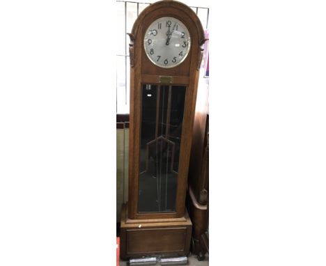 An Art Deco oak longcase clock with weights and pendulum