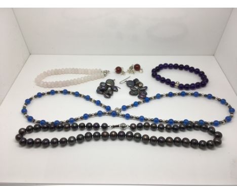 A collection of black pearl and other bead bracelets and necklaces.