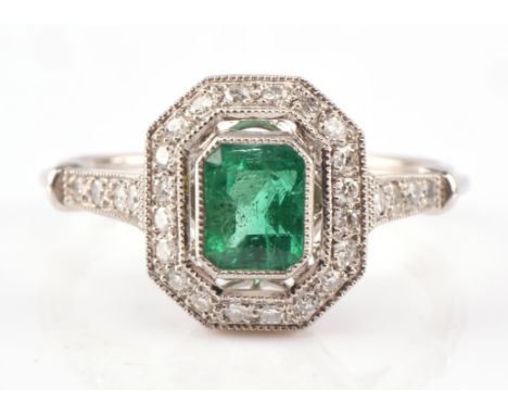 Emerald and diamond ring, central rectangular step cut emerald, estimated weight 0.71 carats, set in a border of single cut d