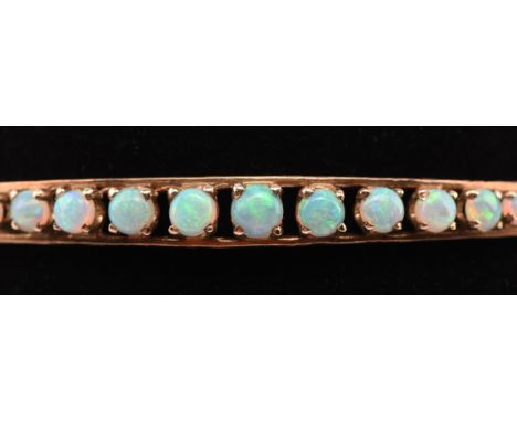 Vintage 9 ct opal bangle, set with fifteen graduating opals bangle measures 63mm in diameter, with safety chain and box clasp