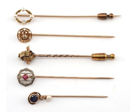Five antique stick pins, including one with a seed pearl and leaf wreath design, a single stone diamond in a round floral cut