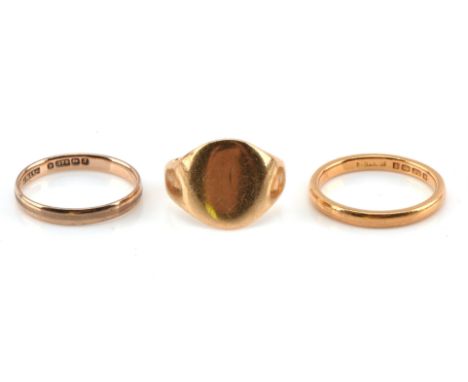 Three gold rings, including a 2.5mm wedding band, in 9 ct, size K 1/2, a 2.4mm wedding band, in 22 ct, size K 1/2, and a sign