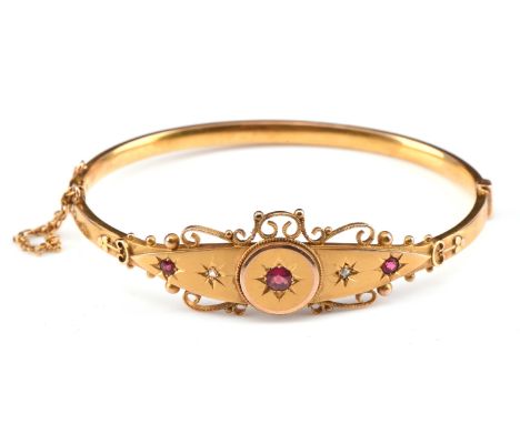 Edwardian hinged bangle with three gypsy set red paste stones and scroll wire work design, 63mm in diameter with box clasp an