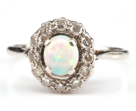 Opal and diamond cluster ring, central oval cabochon cut opal 0.25 carat, surrounded by single cut diamonds, with an estimate