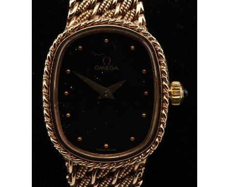 Omega ladies wristwatch in 9 ct gold, oblong black signed dial with circular hour markers and manual wind movement the case b