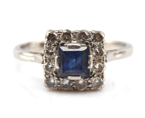Sapphire and diamond cluster ring, square step cut sapphire, estimated weight 0.79 carats, surrounded by round brilliant cut 