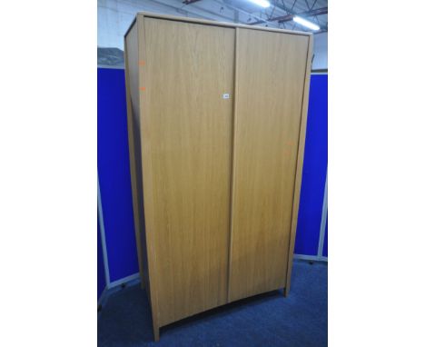 AN ERCOL SAVONA OAK TWO DOOR WARDROBE, enclosing an internal mirror to the right door, and a shelf, width 115cm x depth 59cm 