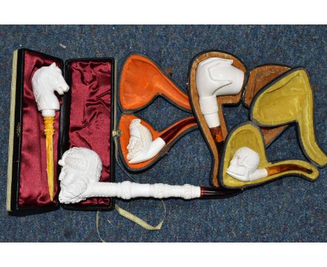 A BOX OF MODERN MEERSCHAUM PIPES AND LETTER OPENER, comprising a horse's head letter opener, a pipe with a carved hand holdin