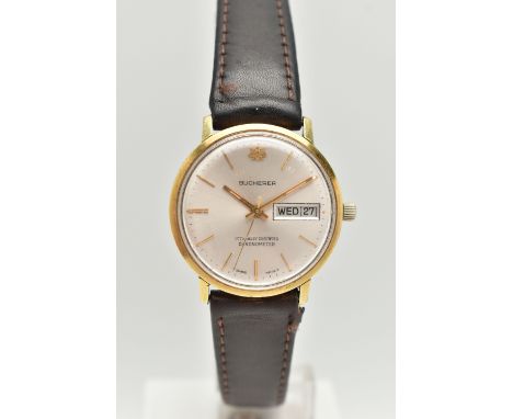 A GENTLEMAN'S BUCHERER WRISTWATCH, the circular face with gold coloured baton markers and hands, day and date dial, face stam
