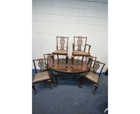 AN EARLY 2OTH CENTURY MAHOGANY OVAL WIND OUT DINING TABLE, the legs with scrolled and foliate detail, on ball and claw feet, 