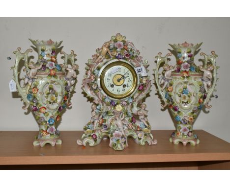 A GERMAN PORCELAIN CLOCK GARNITURE SET,  porcelain clock garniture, late 19th century, the cartouche shaped clock mounted wit