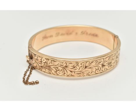 A 9CT ROLLED GOLD HINGED BANGLE, floral detailed bangle, fitted with a push piece clasp with additional safety chain, stamped