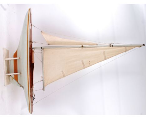 POND YACHT; A vintage model pond yacht, with large white linen sale, moveable rudder and display stand. 105cm tall (on stand)