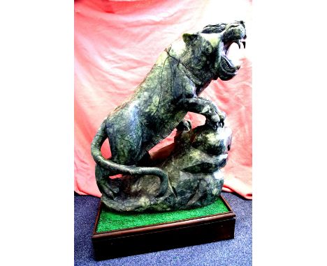 Large Jade roaring tiger, cut from a single piece, imported from Korea c1995, weighs approximately 350 kg on a wheeled base, 